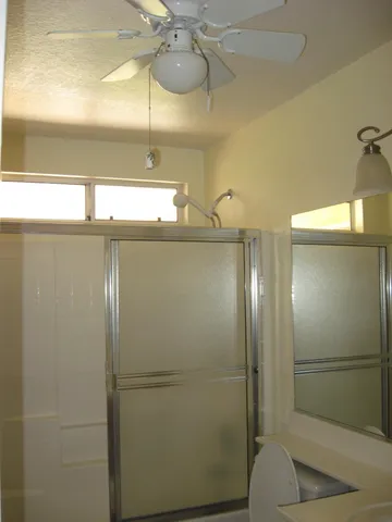 a bathroom with a glass shower door and a window