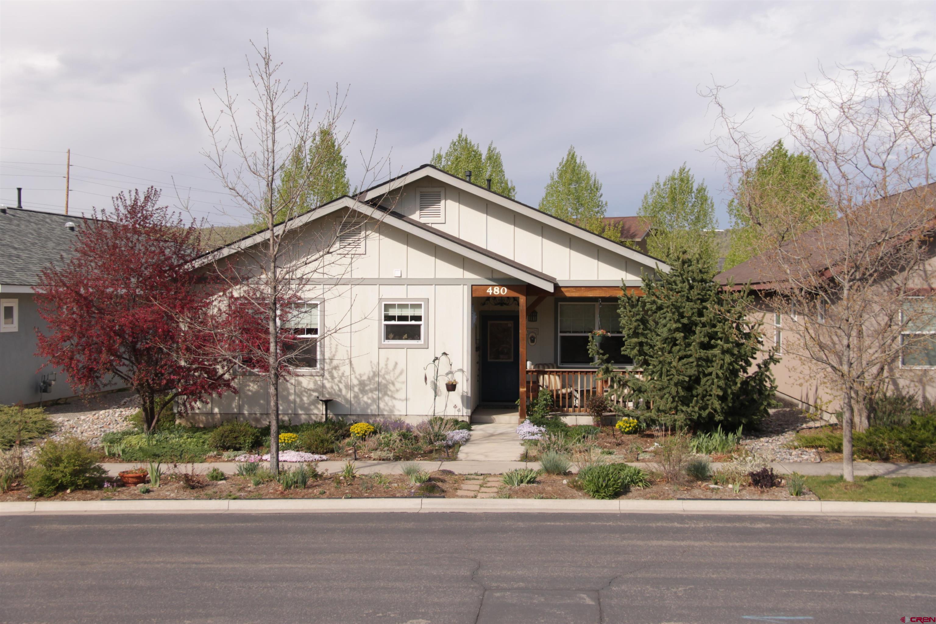 a front view of a house with a yard and potted plants