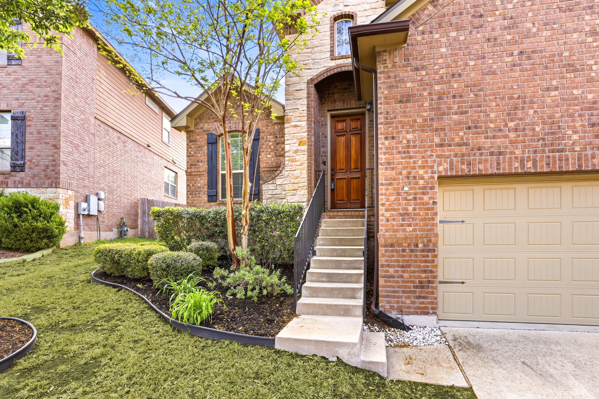 152 Stone View Trail Austin, TX 78737 - Photo 4 of 33 Entrance to property featuring brick siding, a garage, and concrete driveway
