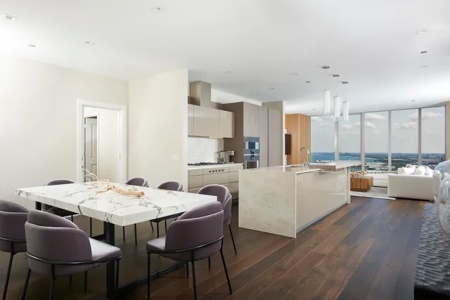 a large white kitchen with a table and chairs