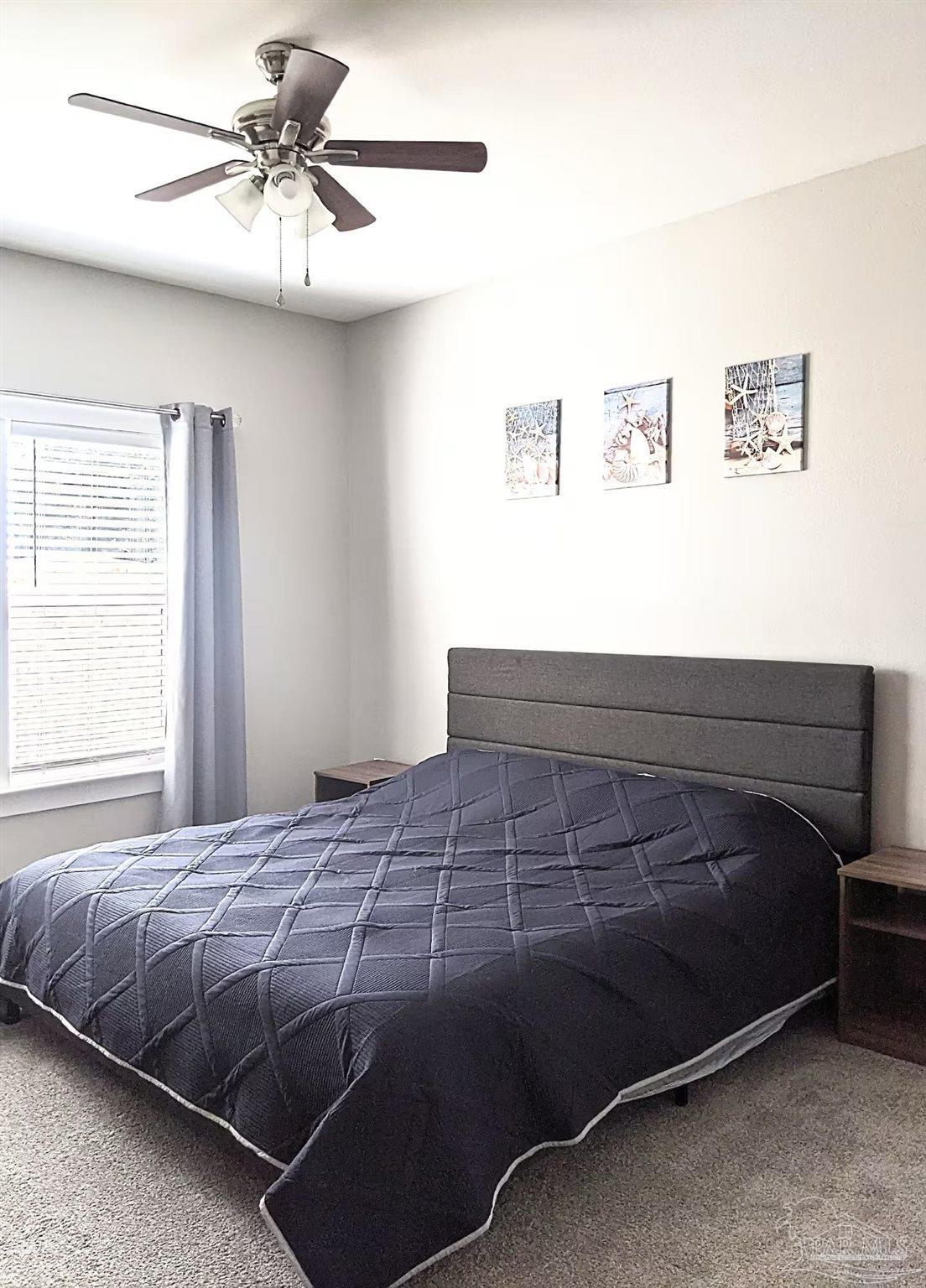 5446 Medina Road Pensacola, FL 32507 - Photo 5 of 11 a bedroom with a bed and a chandelier