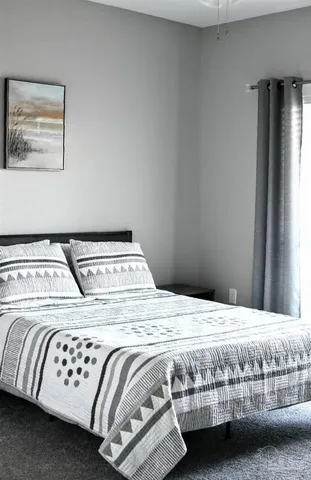 a bedroom with a bed and a window