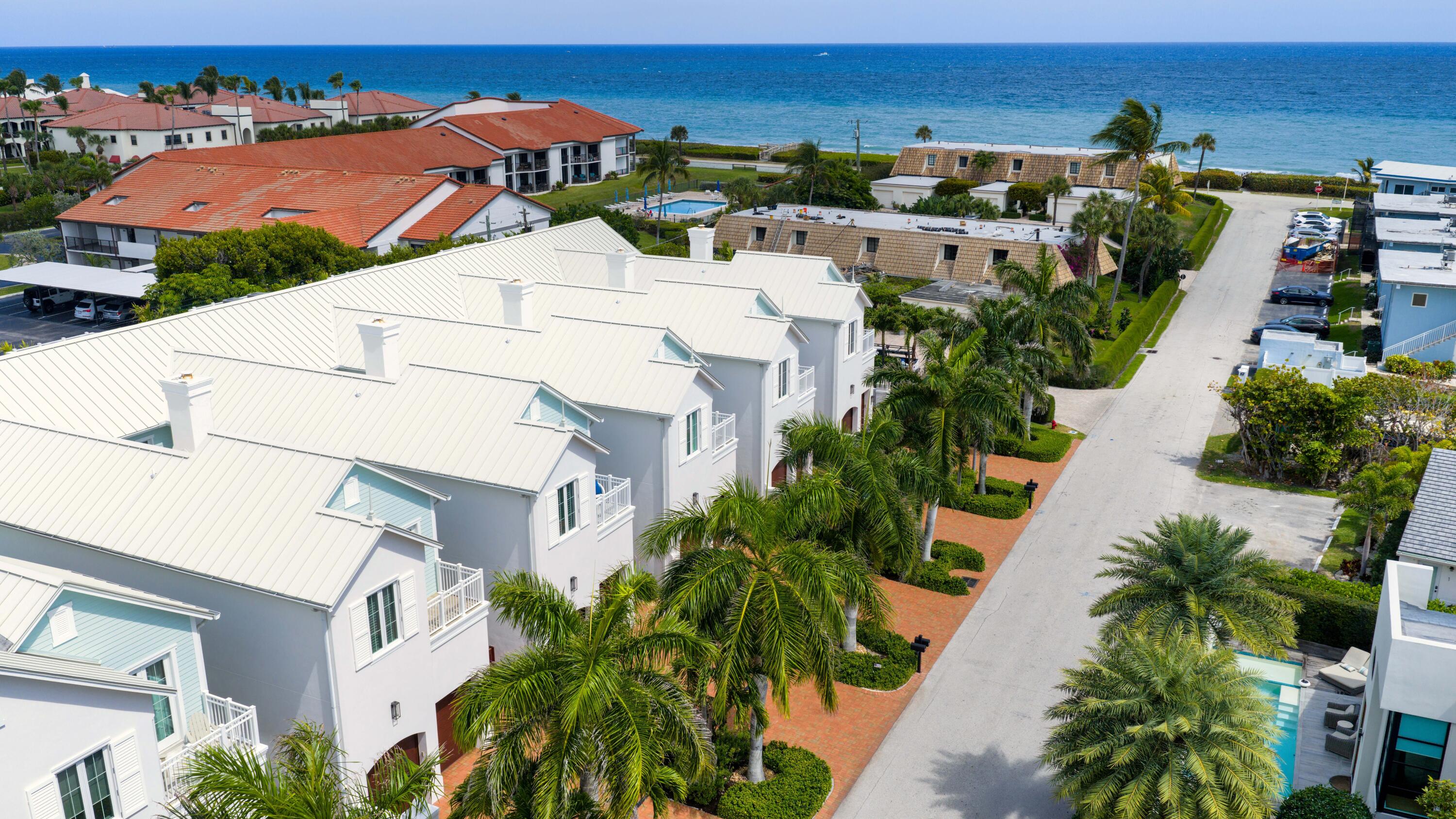 an aerial view of residential houses with outdoor space and trees