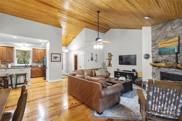 a living room with furniture a flat screen tv and kitchen view
