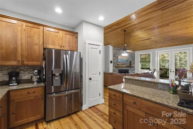 a kitchen with granite countertop a refrigerator stove top oven and sink