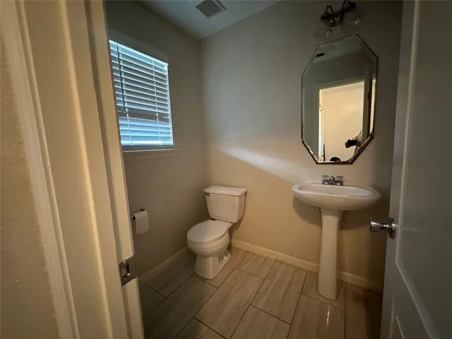a bathroom with a toilet a sink and a mirror