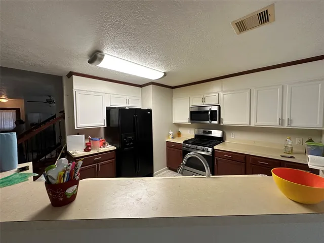 a kitchen with stainless steel appliances granite countertop a refrigerator and a stove top oven
