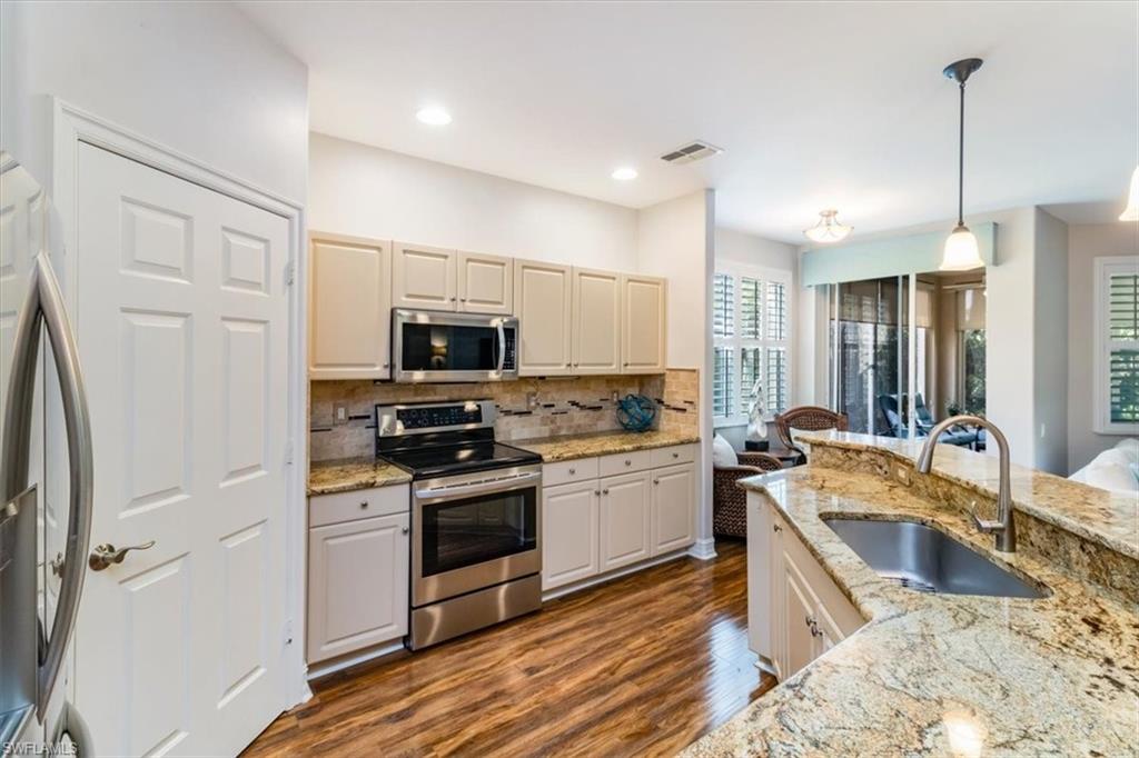 873 Carrick Bend Circle, Unit 101 Naples, FL 34110 - Photo 11 of 42 a kitchen with a sink stove and refrigerator