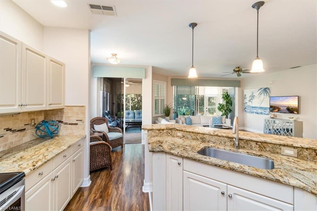 873 Carrick Bend Circle, Unit 101 Naples, FL 34110 - Photo 12 of 42 a kitchen with sink refrigerator and window