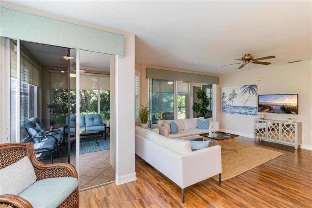 873 Carrick Bend Circle, Unit 101 Naples, FL 34110 - Photo 24 of 42 a living room with furniture and a large window