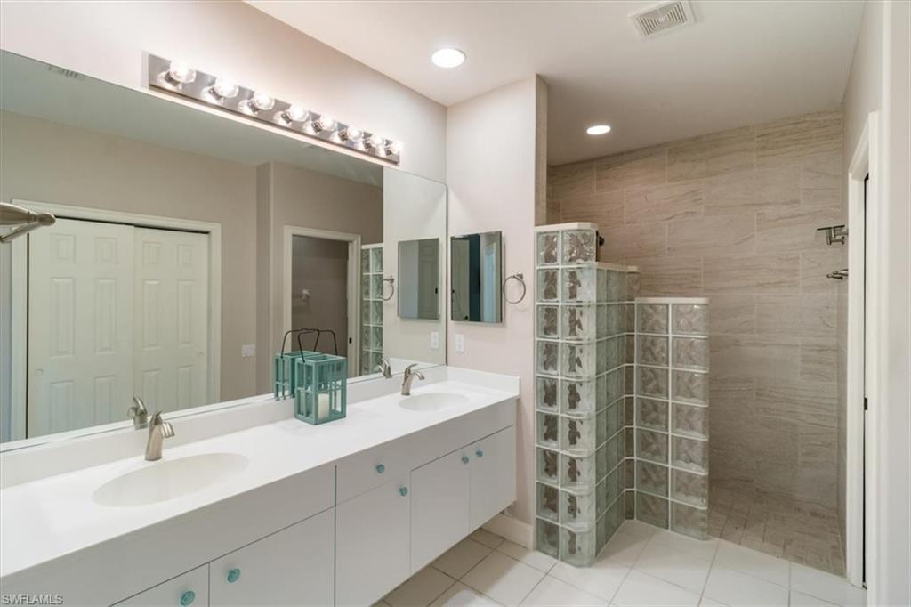 873 Carrick Bend Circle, Unit 101 Naples, FL 34110 - Photo 27 of 42 a bathroom with a double vanity sink mirror and double