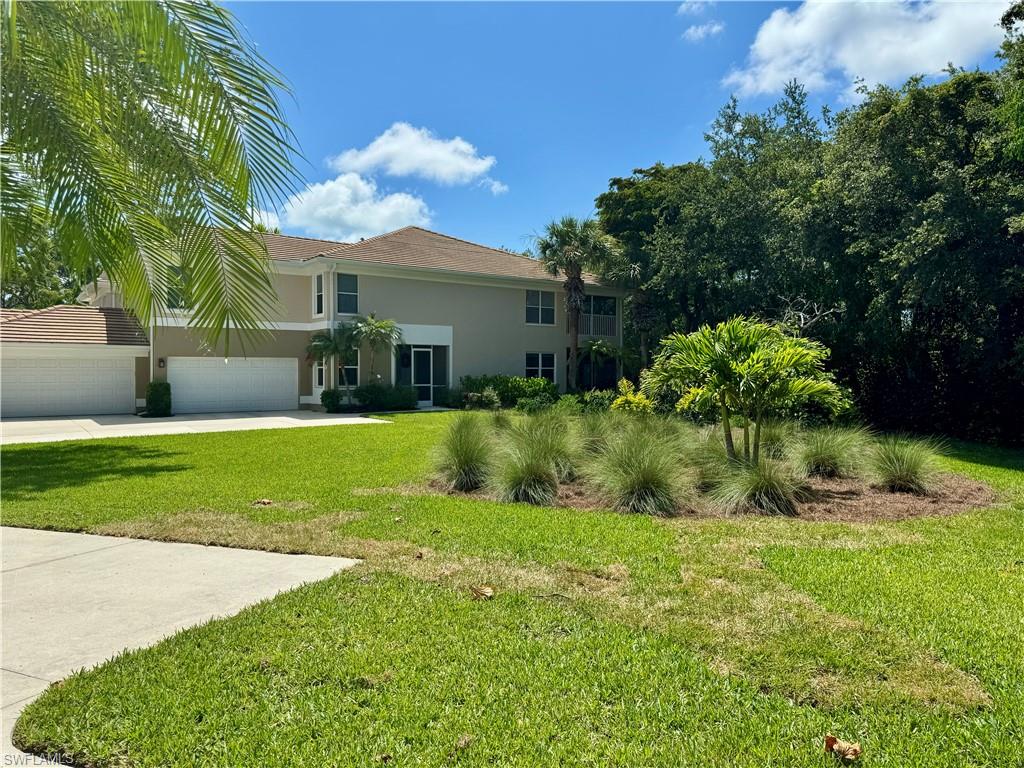 873 Carrick Bend Circle, Unit 101 Naples, FL 34110 - Photo 3 of 42 a view of a house with a big yard and potted plants