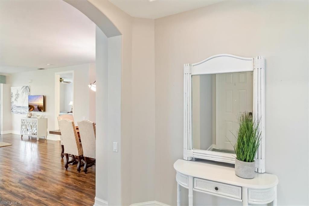 873 Carrick Bend Circle, Unit 101 Naples, FL 34110 - Photo 5 of 42 a view of a hallway with wooden floor and a potted plant