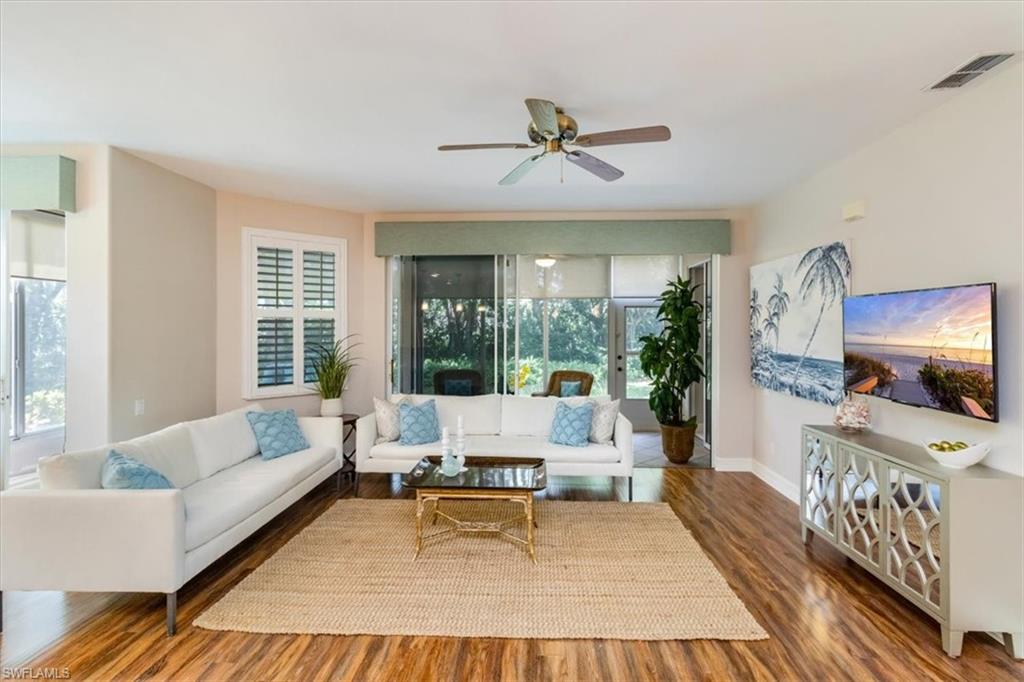 873 Carrick Bend Circle, Unit 101 Naples, FL 34110 - Photo 6 of 42 a living room with furniture and a flat screen tv