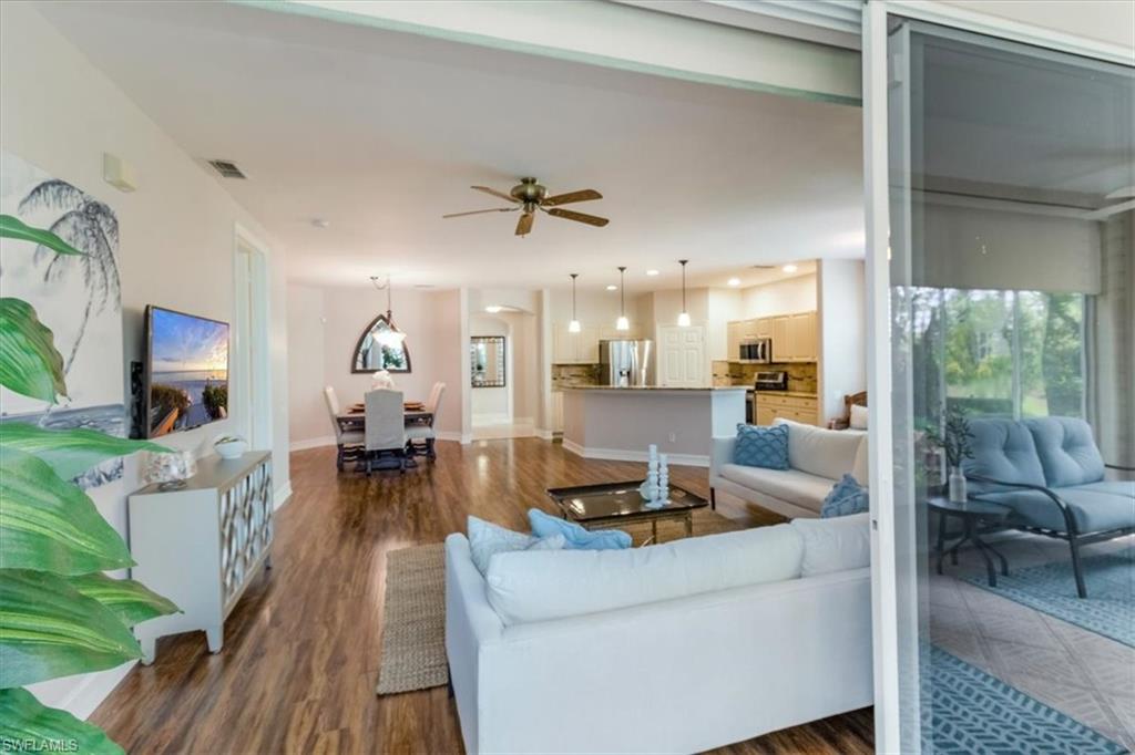 873 Carrick Bend Circle, Unit 101 Naples, FL 34110 - Photo 7 of 42 a living room with furniture and a wooden floor