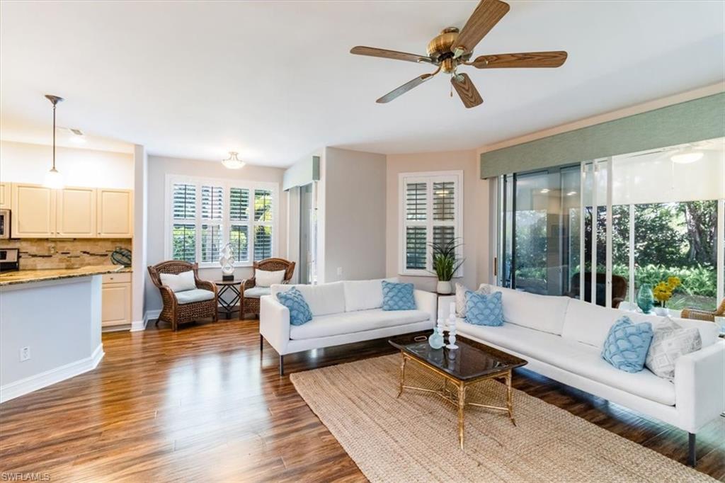 873 Carrick Bend Circle, Unit 101 Naples, FL 34110 - Photo 9 of 42 a living room with furniture and a large window with outer view