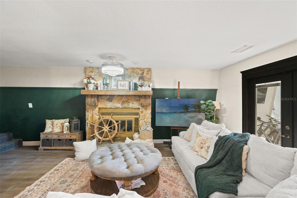 6271 Colony Circle Weeki Wachee, FL 34607 - Photo 12 of 60 a living room with furniture a fireplace and a chandelier