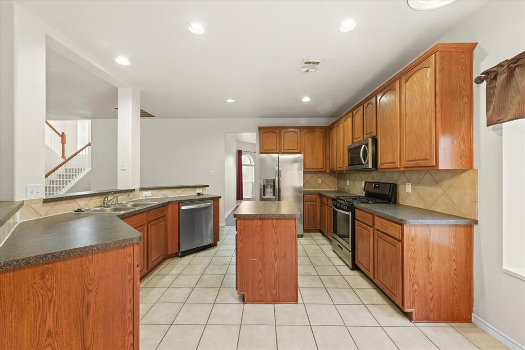 1701 Balboa Lane Allen, TX 75002 - Photo 11 of 30 a large kitchen with stainless steel appliances granite countertop a stove top oven a sink dishwasher and cabinets