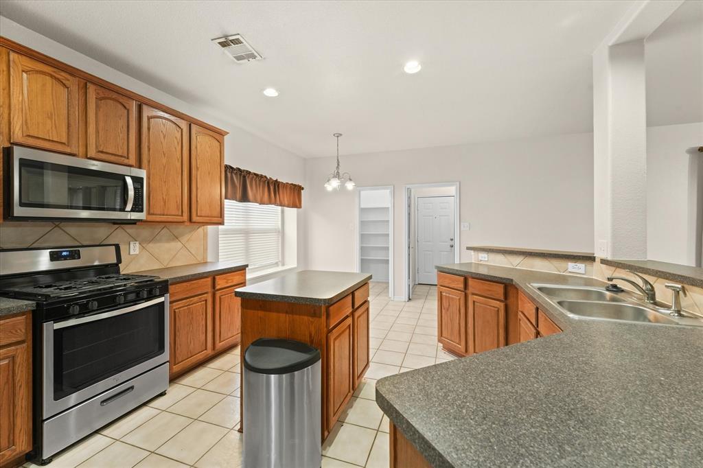 1701 Balboa Lane Allen, TX 75002 - Photo 12 of 30 a kitchen with stainless steel appliances granite countertop a sink stove and refrigerator