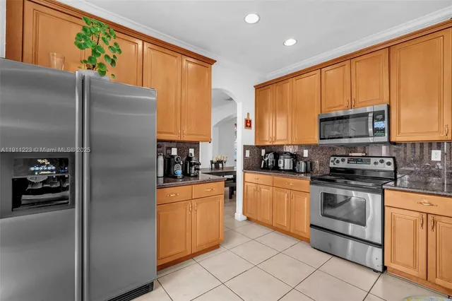 a kitchen with stainless steel appliances granite countertop a refrigerator a stove top oven a sink and dishwasher