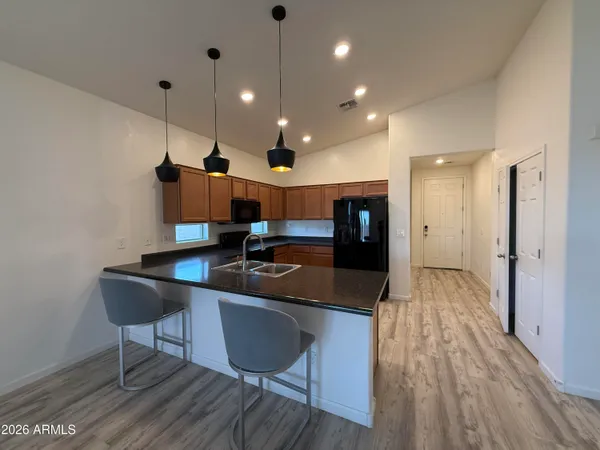 a kitchen with stainless steel appliances granite countertop a sink refrigerator and cabinets