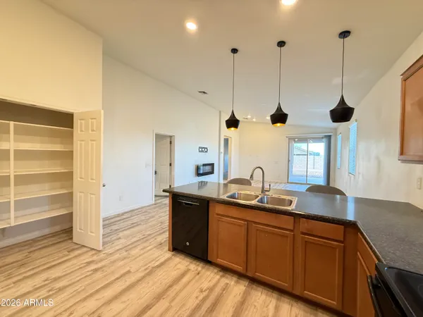 a kitchen with stainless steel appliances granite countertop a sink a window and wooden floor