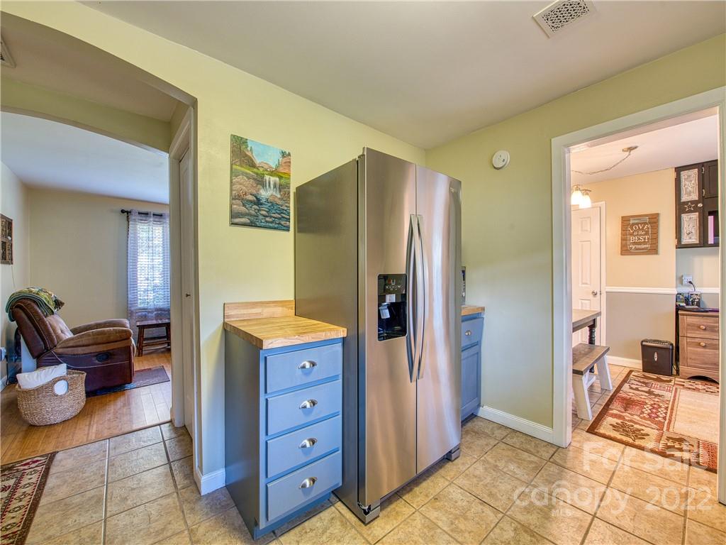 550 Lickstone Road Waynesville, NC 28786 - Photo 11 of 24 a kitchen with a refrigerator and wooden cabinets