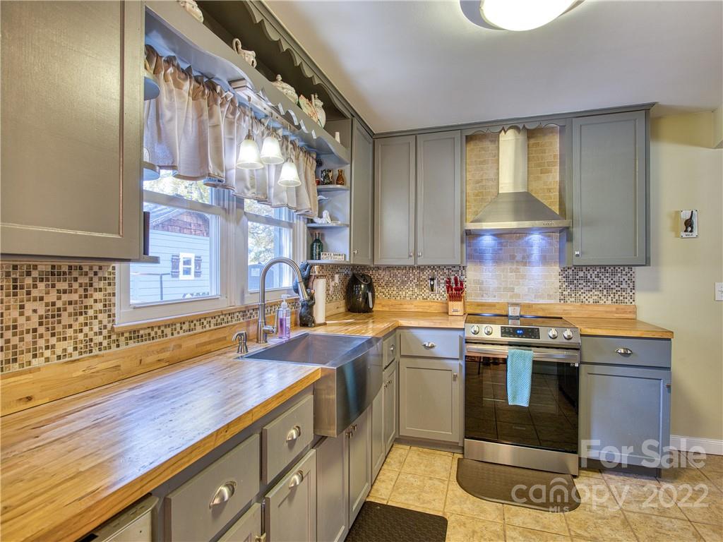 550 Lickstone Road Waynesville, NC 28786 - Photo 13 of 24 a kitchen with stainless steel appliances granite countertop a sink a stove and a wooden cabinets
