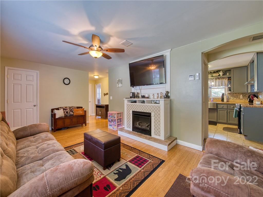 550 Lickstone Road Waynesville, NC 28786 - Photo 15 of 24 a living room with furniture a flat screen tv and a fireplace