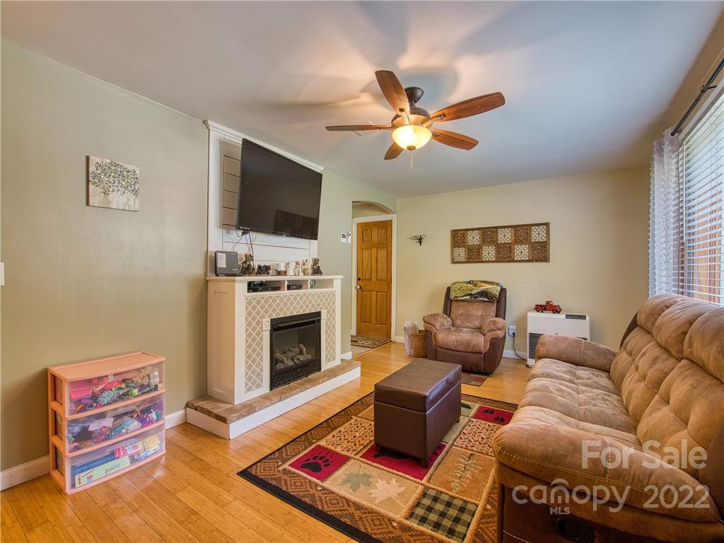 550 Lickstone Road Waynesville, NC 28786 - Photo 16 of 24 a living room with furniture a flat screen tv and a fireplace
