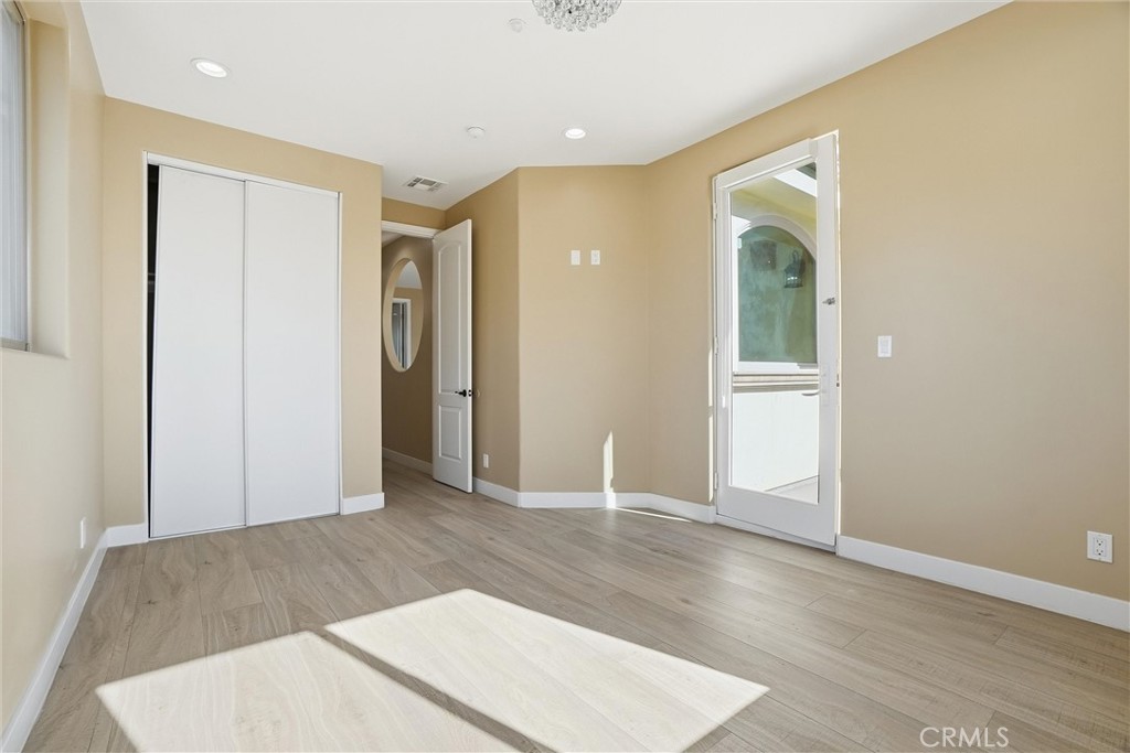 127 West 219th Place Carson, CA 90745 - Photo 22 of 69 Bedroom with glass door enjoying access to a front balcony with craftsman-style column railings, perfect for morning sun or evening stargazing. Shared hallway bathroom with third bedroom.