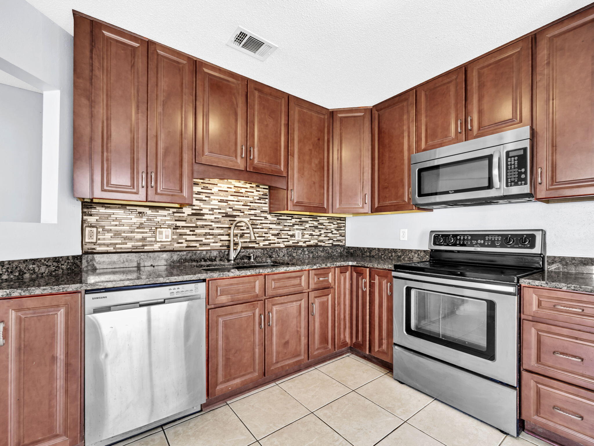 3024 Yorktown Circle Fort Walton Beach, FL 32547 - Photo 11 of 24 a kitchen with granite countertop wooden cabinets stainless steel appliances and a sink