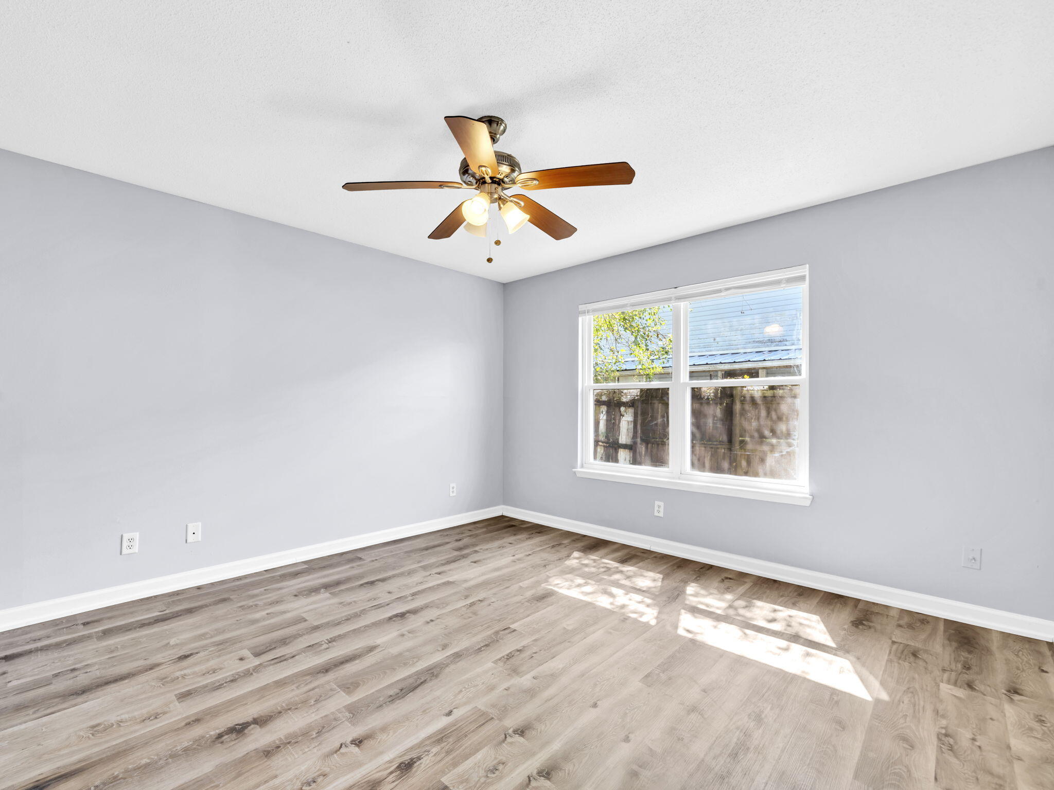 3024 Yorktown Circle Fort Walton Beach, FL 32547 - Photo 14 of 24 a view of an empty room with wooden floor and a window
