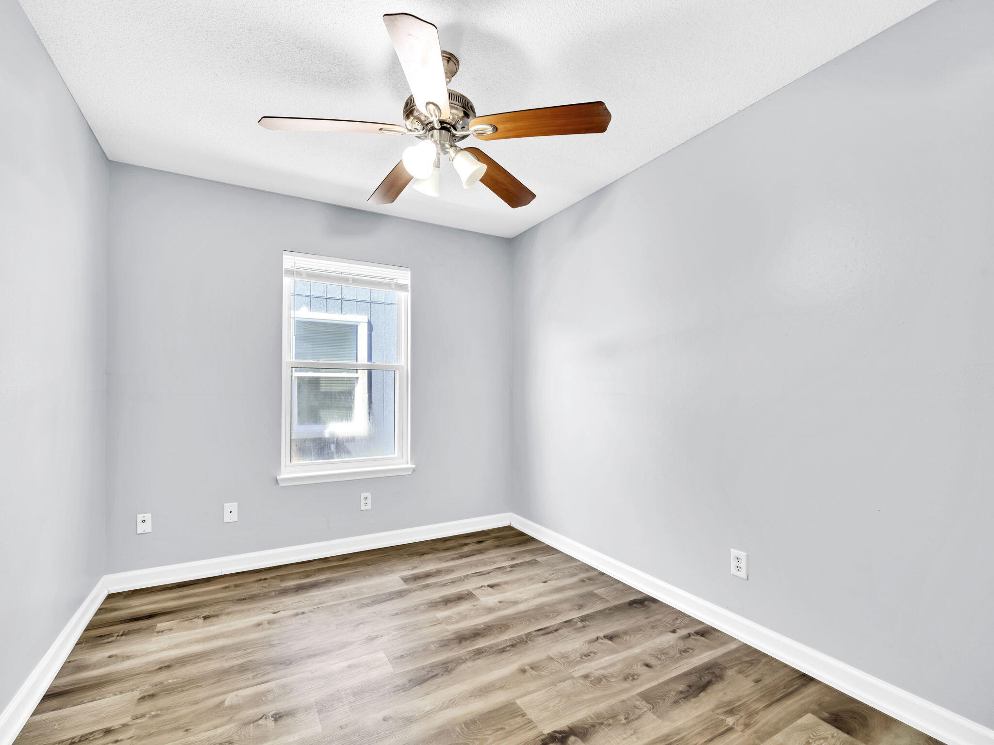 3024 Yorktown Circle Fort Walton Beach, FL 32547 - Photo 18 of 24 an empty room with wooden floor fan and windows