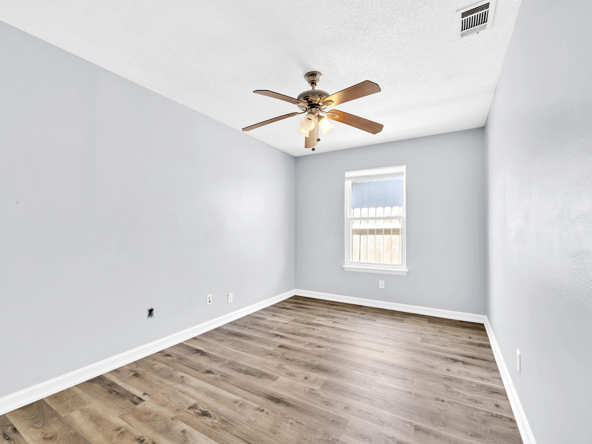 3024 Yorktown Circle Fort Walton Beach, FL 32547 - Photo 20 of 24 a view of empty room with wooden floor and fan