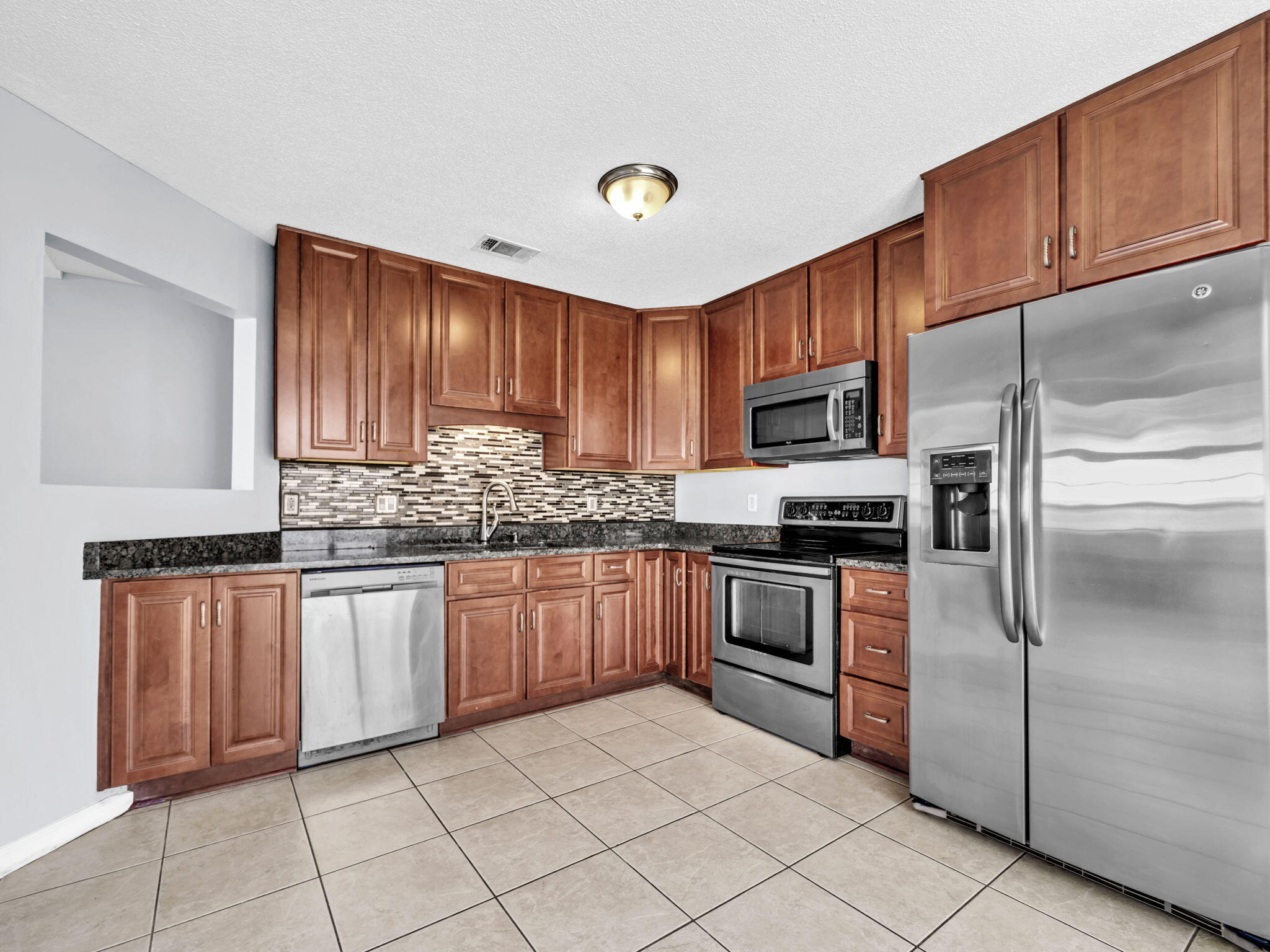 3024 Yorktown Circle Fort Walton Beach, FL 32547 - Photo 9 of 24 a kitchen with granite countertop a refrigerator sink and cabinets