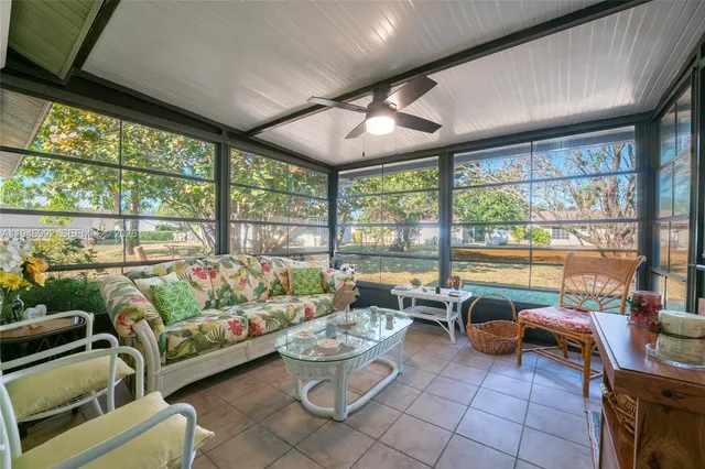 a living room with patio furniture and a floor to ceiling window