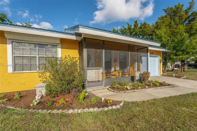 a view of a house with backyard and sitting area