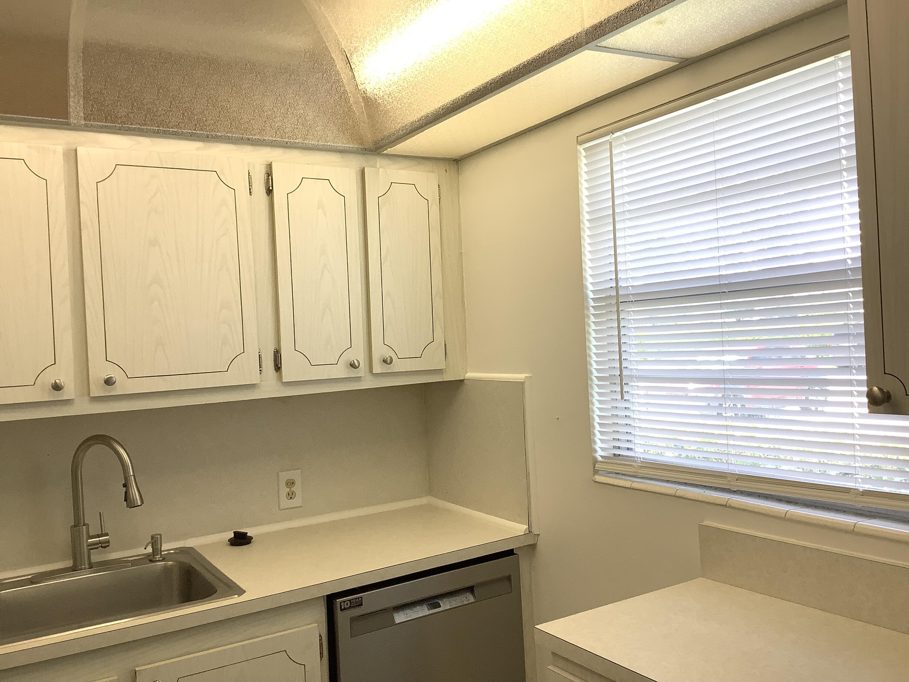 560 Fanshaw North, Unit 560 Boca Raton, FL 33434 - Photo 4 of 26 a sink with window and cabinets
