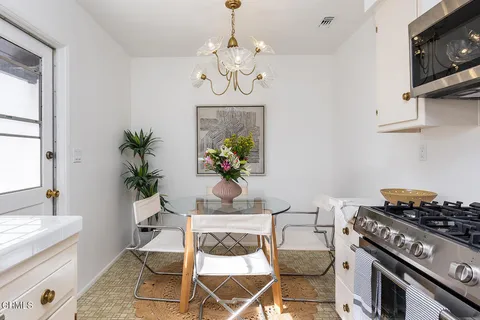 a dining room with wooden floor a chandelier a wooden table and chairs