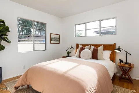 a bed sitting in a bedroom next to a window
