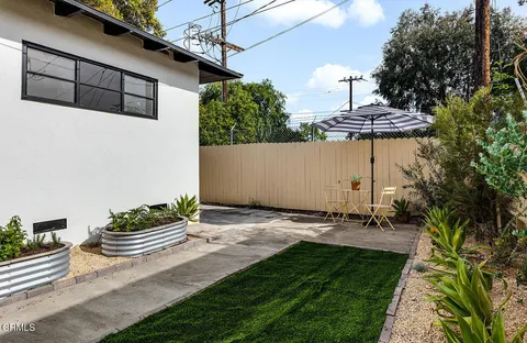 a backyard of a house with table and chairs