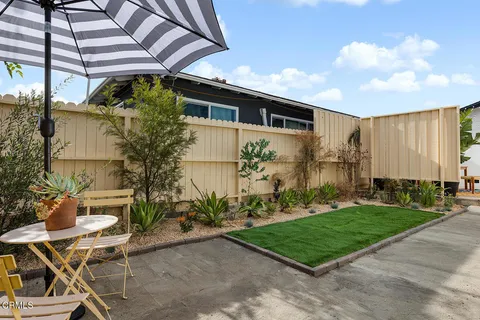 a backyard of a house with table and chairs