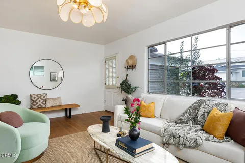 a living room with furniture chandelier and a large window