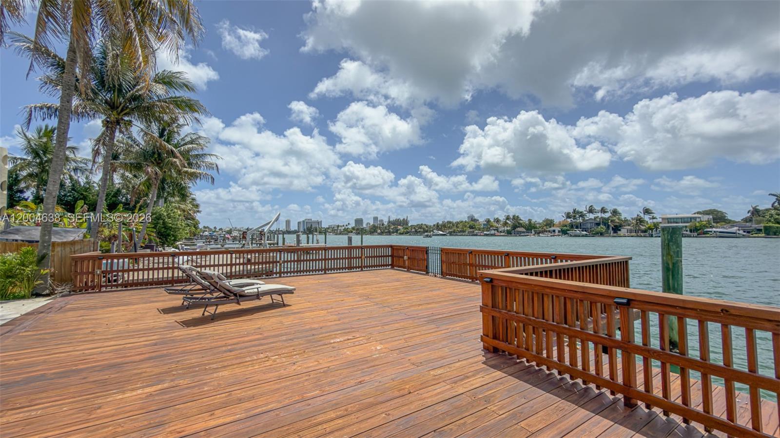 1690 Daytonia Road Miami Beach, FL 33141 - Photo 26 of 88 a view of a roof deck with table and chairs a barbeque with wooden floor and fence