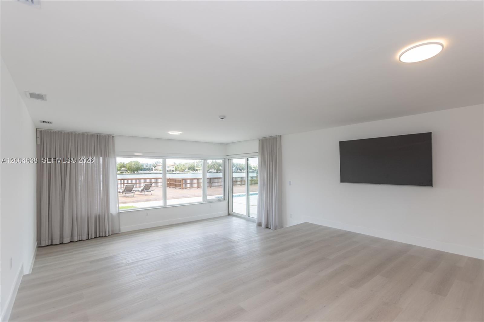 1690 Daytonia Road Miami Beach, FL 33141 - Photo 69 of 88 a view of an empty room with a window and wooden floor