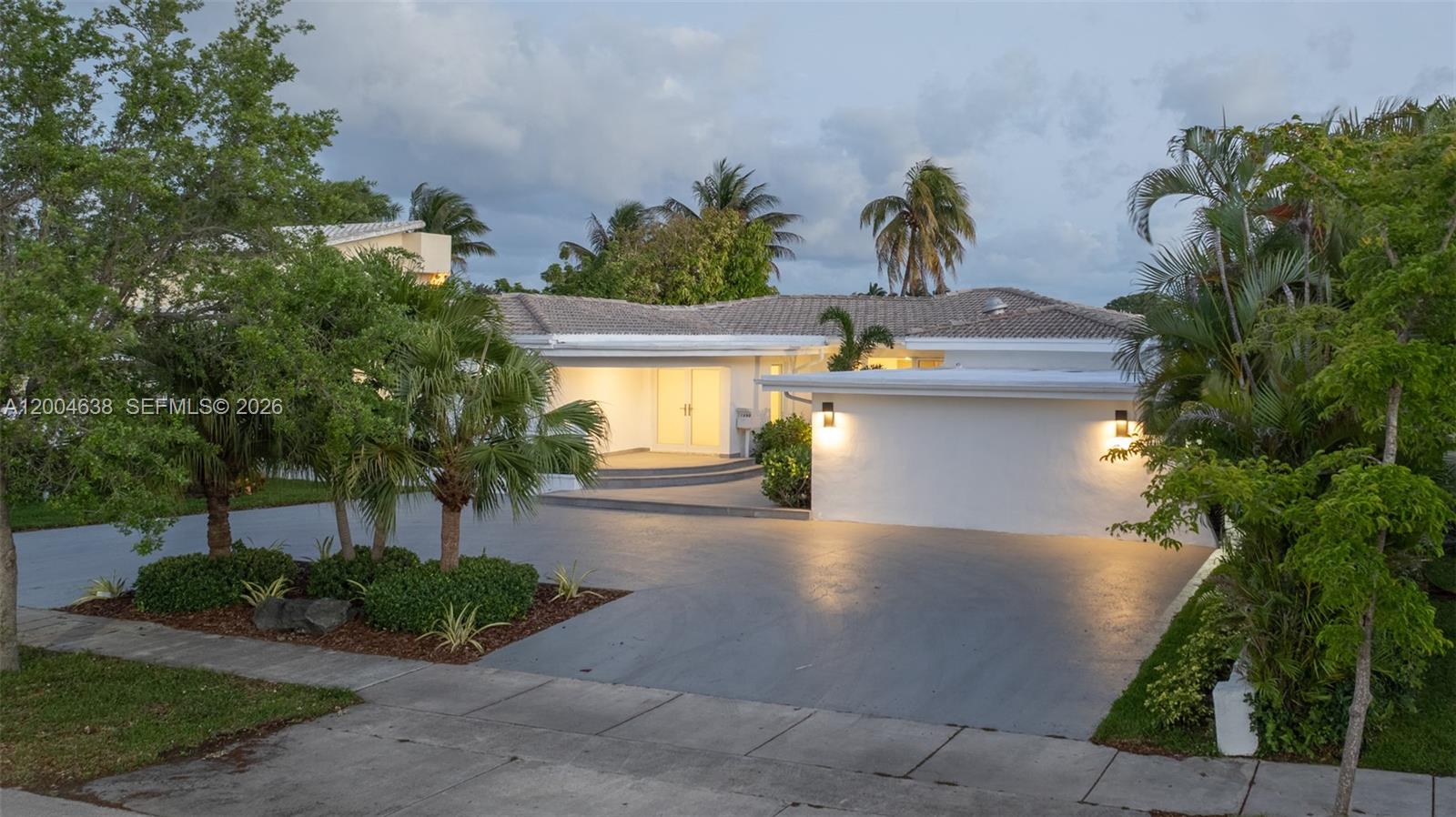 1690 Daytonia Road Miami Beach, FL 33141 - Photo 7 of 88 a front view of a house with a yard and a garden