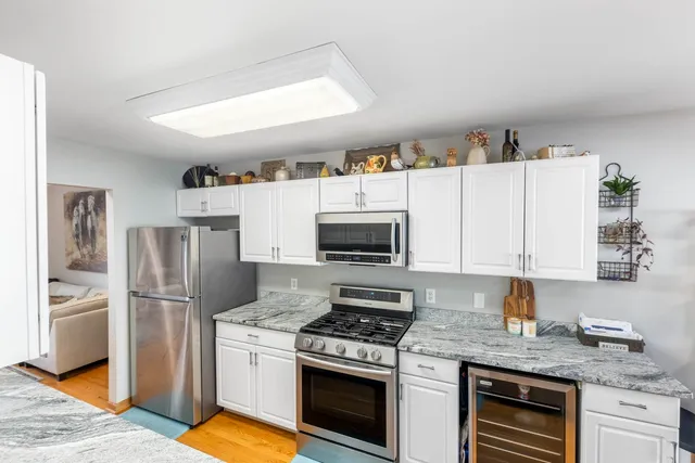 a kitchen with stainless steel appliances granite countertop a stove refrigerator and microwave