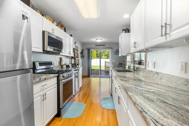 a kitchen with stainless steel appliances granite countertop a stove a sink and a microwave