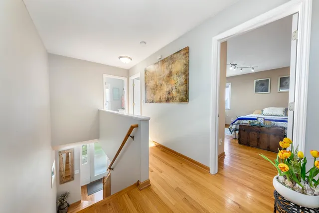 a view of a hallway with wooden floor and furniture